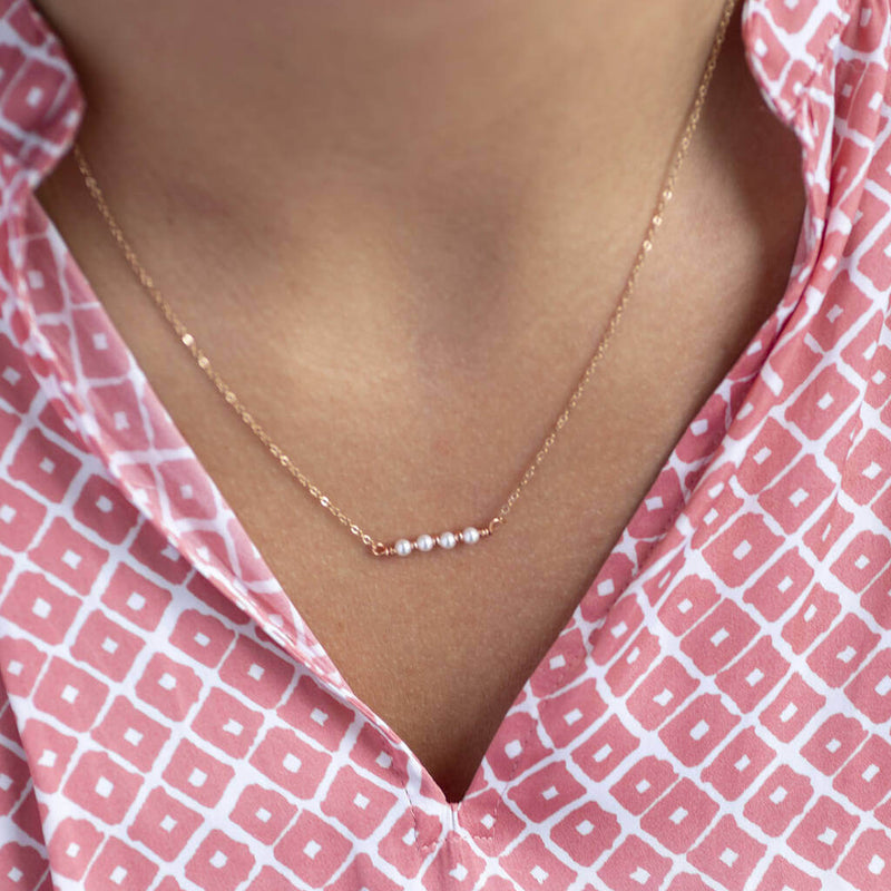 Image shows model wearing rose gold 40th birthday dainty pearl bar necklace
