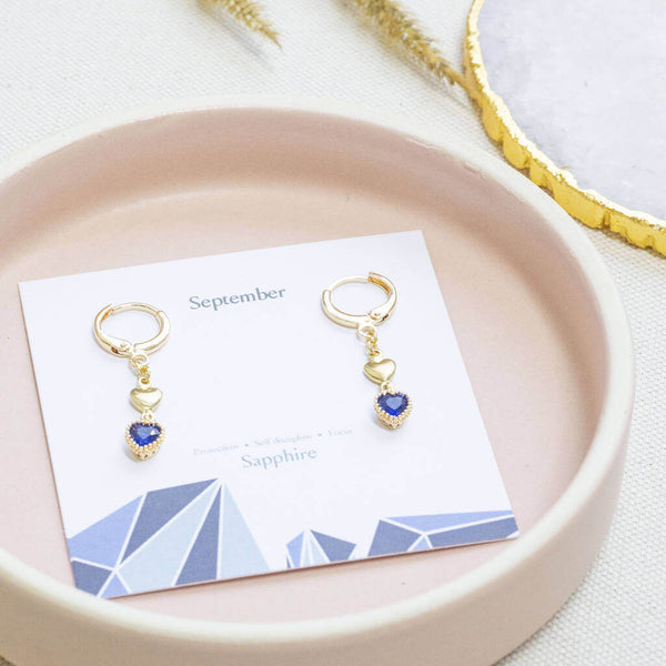 Image shows Double Heart Sapphire Birthstone Earrings on a September birthstone characteristic card