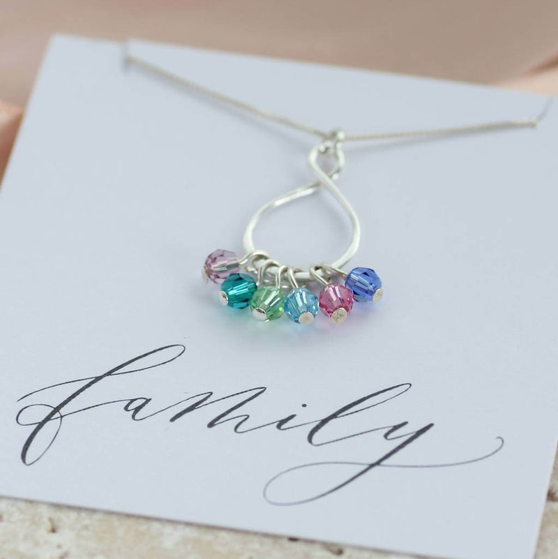 Image shows family eternity birthstone necklace on a family sentiment card