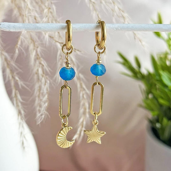 Image shows Frosted Blue Moon and Star Earrings hanging from a white rail