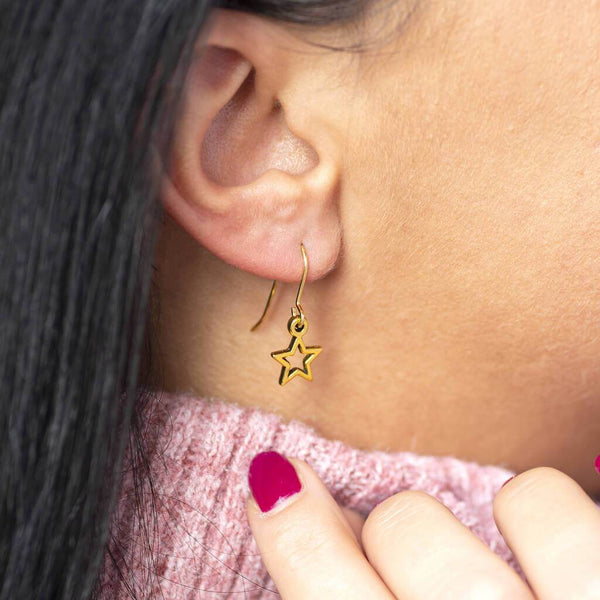Image shows model wearing gold star earrings