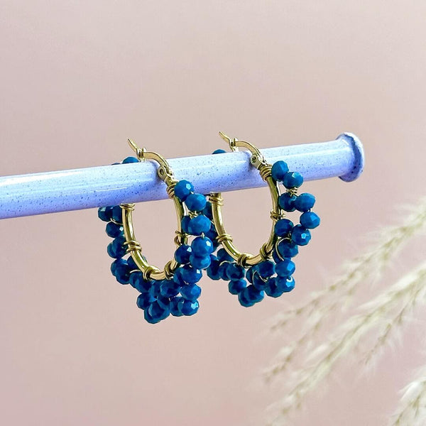 Image shows Indigo Beaded Crystal Hoops hanging from a pole