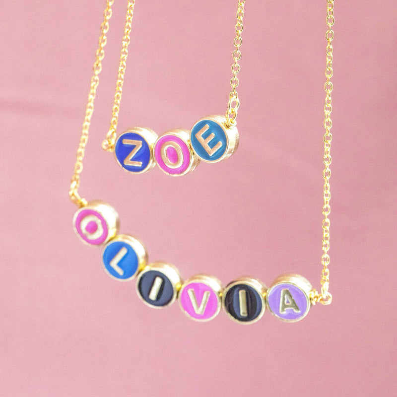  Image shows two hanging personalised enamel disc name necklaces with the names Zoe and Olivia