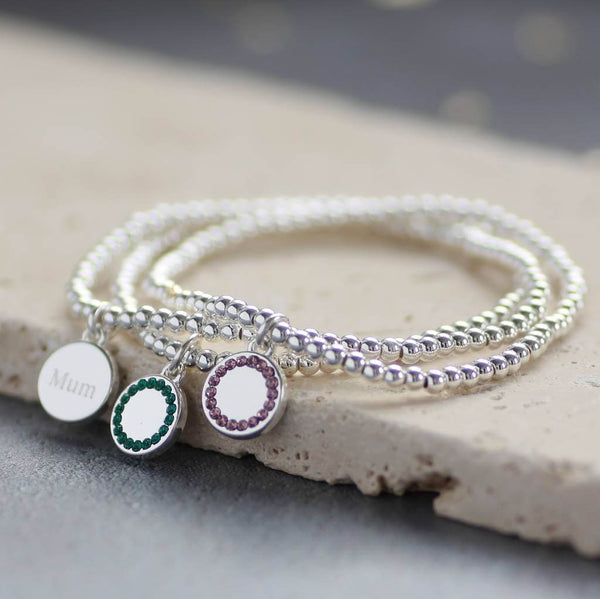 Image shows three personalised birthstone stretch bracelets one with mum detail engraved on the back