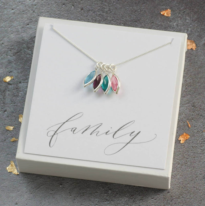 Image shows sterling silver chain with marquise birthstones April crystal, January garnet red, December blue zircon and October rose pink on a white 'family' sentiment card.