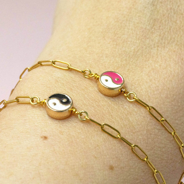 Image shows model wearing  ying and yang coloured enamel bracelet