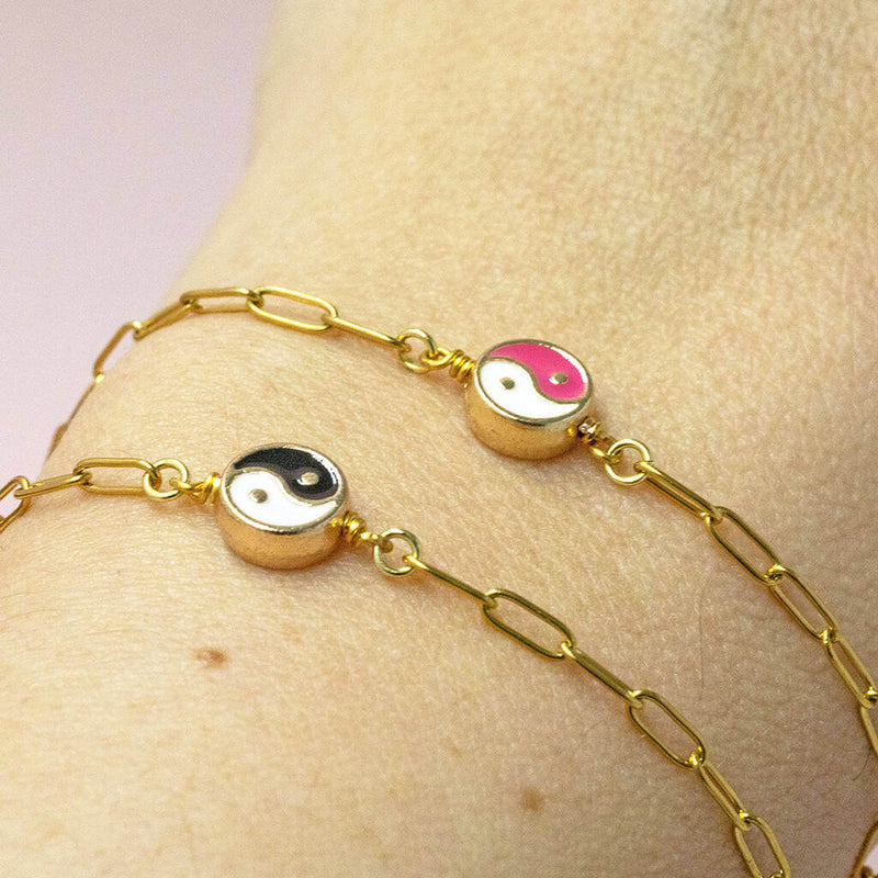 Image shows model wearing  ying and yang coloured enamel bracelet