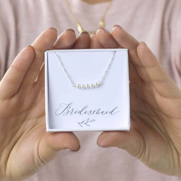 Model holds the delicate Swarovski pearl necklace in the box on the bridesmaid sentiment card