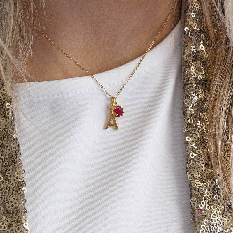 Model wears Gold Plated Initial and Birthstone Star Necklace 'A' with July Ruby 
