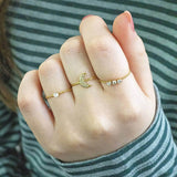Model wears trio of stacking rings - single solitaire on the left.