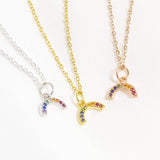 Image shows three dainty rainbow crystal encrusted necklaces on a white backdrop. From left to right: silver plated, gold plated and rose gold plated. Each with nine tiny multicoloured crystals to make the rainbow. 