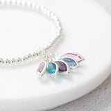 Image shows silver plated family marquise style birthstone bracelet with June light amethyst, December blue zircon, February amethyst, March aquamarine and October rose swarovski birthstones. 