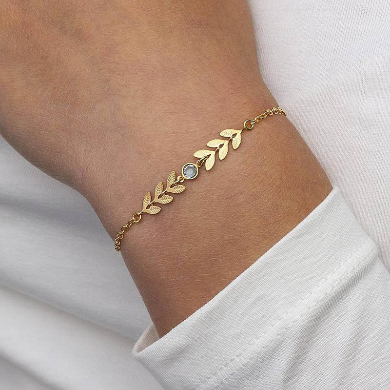 Model wears gold leaf vine bracelet with April Crystal birthstone detail.