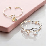 image shows gold and silver friendship knot bangles personalised with initial and birthstone charms