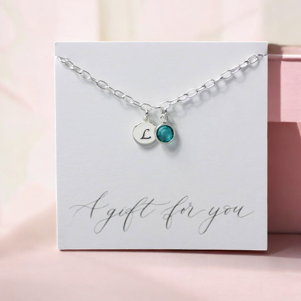 image shows a personalised silver birthstone charm bracelet on a white card that reads a gift for you