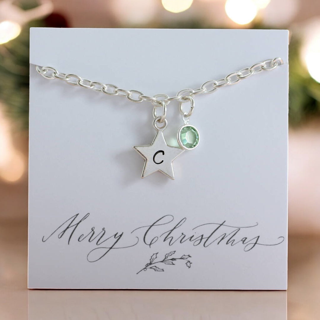 image shows a personalised star charm bracelet with birthstone on a merry christmas card