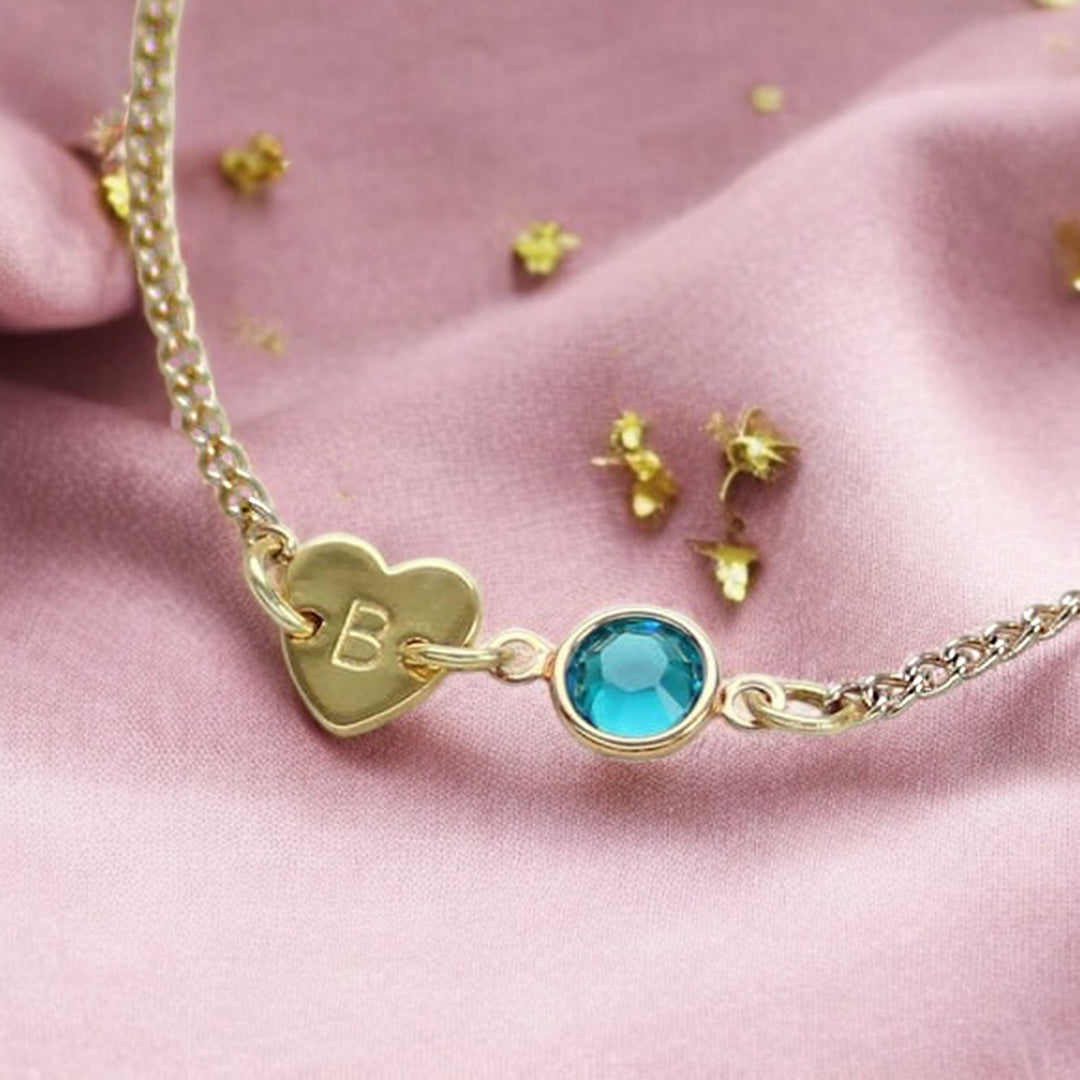 image shows a gold heart bracelet personalised with initial B nd December birthstone