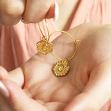 Image shows a woman's hands holding a pair of  personalises inital textured hexagon hoop earrings