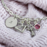 Image shows a silver personalised 21st birthday charm bracelet on a lilac wool background