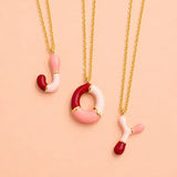 Pink enamel personalised initial necklaces with J O and Y letter pendants on gold chains