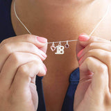 Image shows model holding a 18th  birthday sterling silver charm necklace 