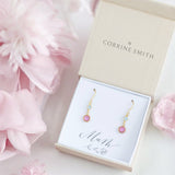 image shows a gift box containing a pair of gold mother and child birthstone earrings on a white card that reads mum