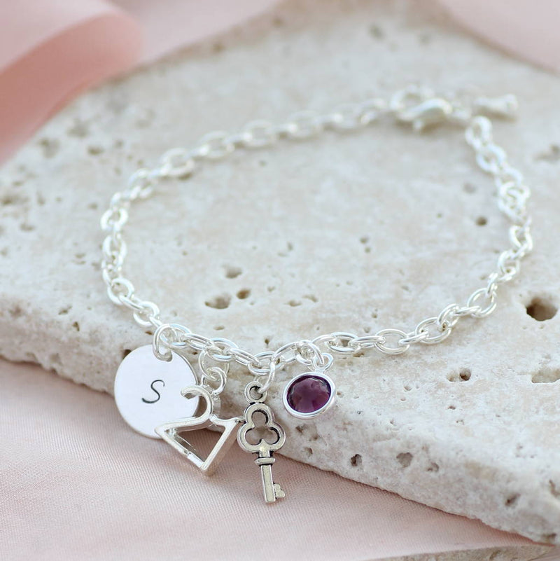 Image shows 21st birthday personalised charm bracelet with initial disc s  and amethyst birthstone