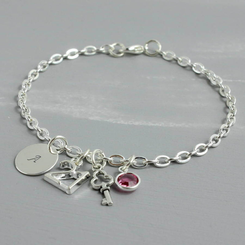 Image shows 21st birthday personalised charm bracelet with initial disc A and Rose birthstone