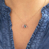 Image shows a woman in a denim top wearing a personalised rose gold family birthstone necklace