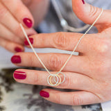 Image shows model holding 30th birthday triple circle necklace