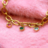 Gold bracelet with heartcshaped charms on a pink fur background