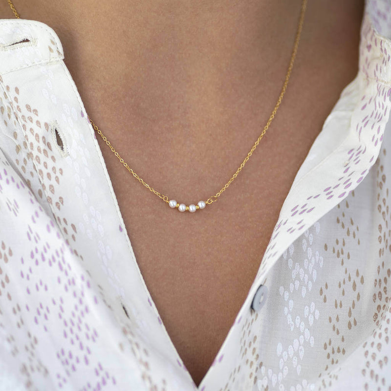 Image shows model wearing gold 40th birthday dainty pearl bar necklace
