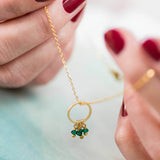 Image shows model holding a gold 40th birthday floating circle birthstone charm necklace