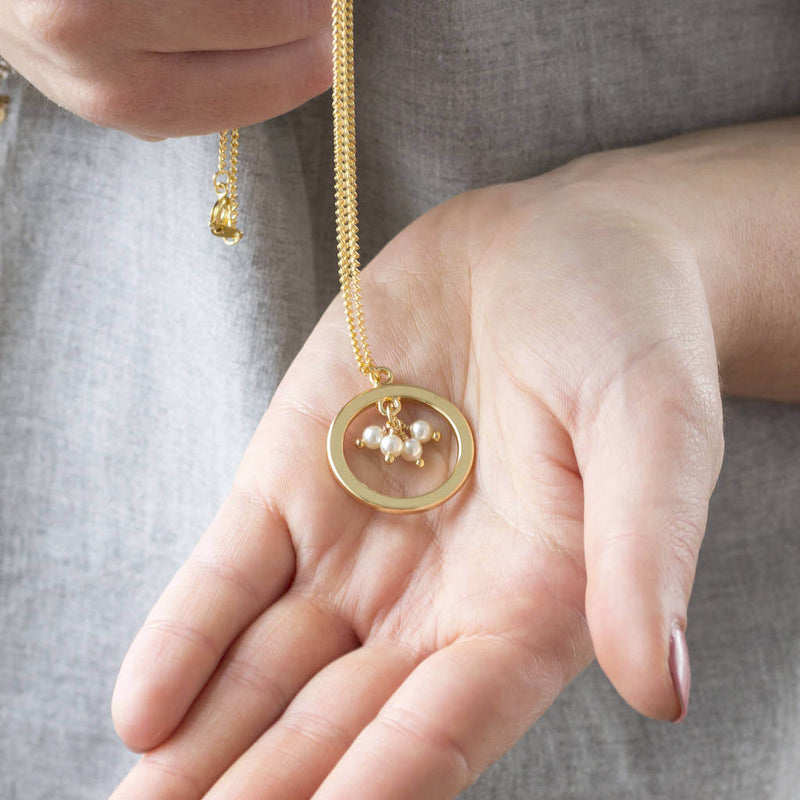 Image shows model holding 40th birthday gold circle pearl necklace