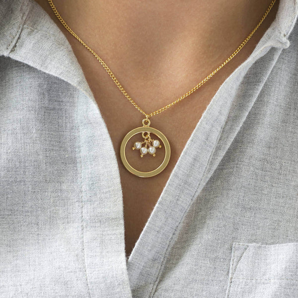 Image shows model wearing 40th birthday gold circle pearl necklace