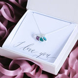 image shows a family birthstone charm pendant necklace on a white card that reads I love you