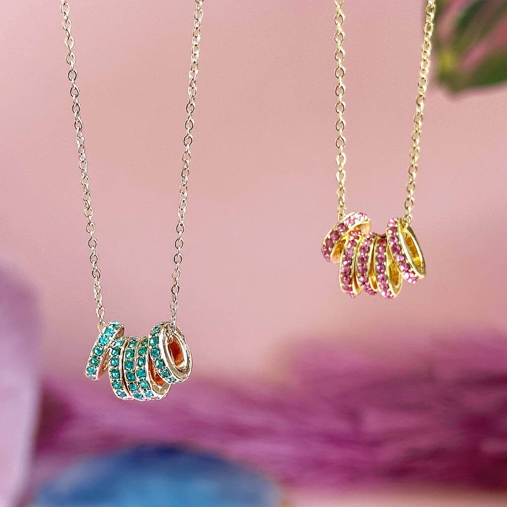 Image shows silver and gold 50th Birthday Birthstone Rings Necklace hanging side by side