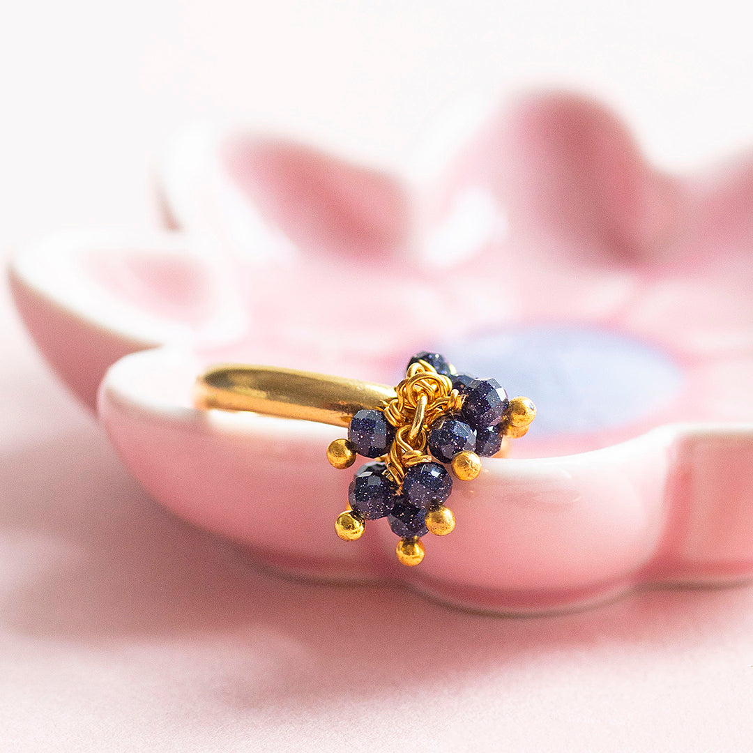 Image shows a beaded blue sandstone cocktail charm ring in a pink trinket dish