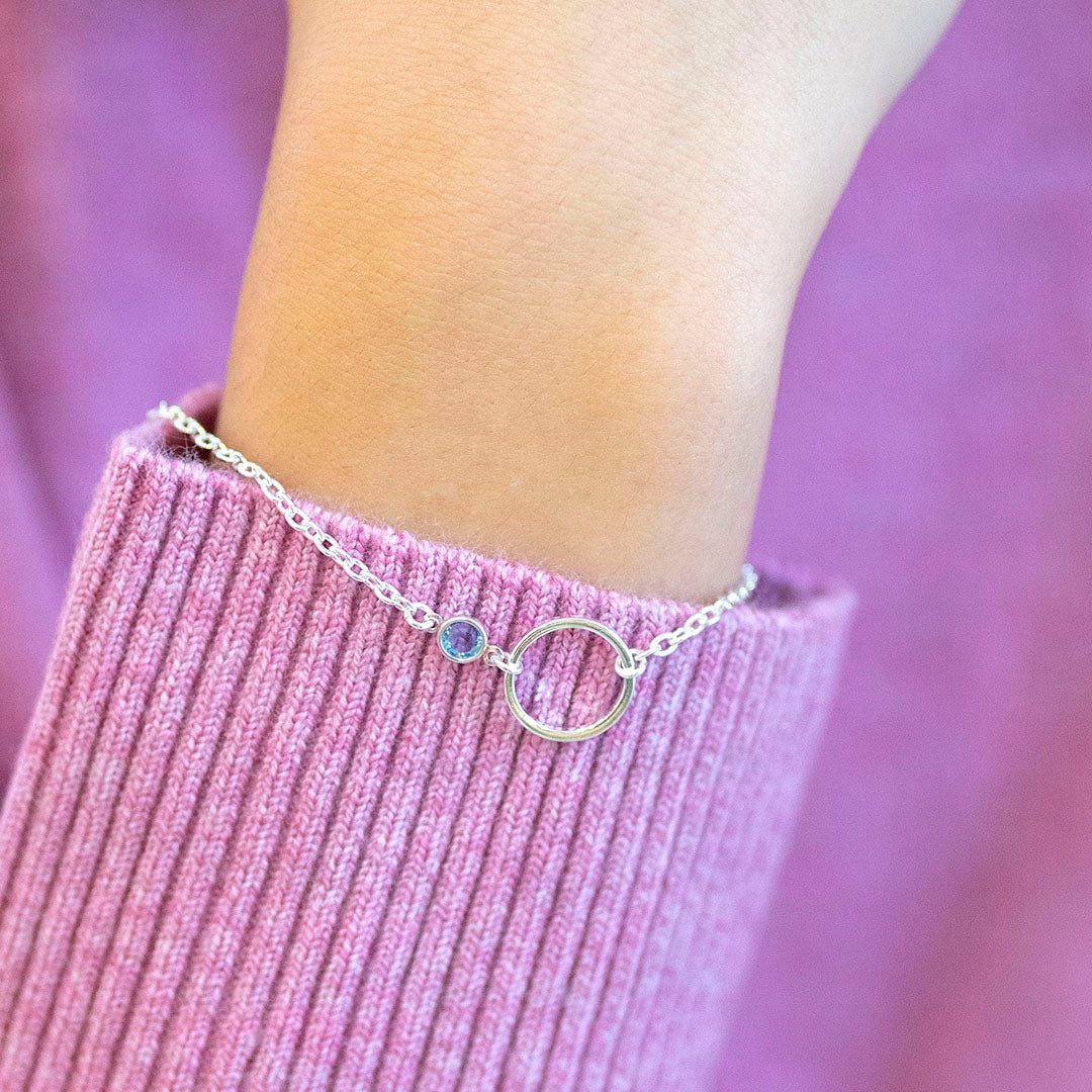 Silver plated Mother and Child Circle Birthstone Bracelet with aquamarine stone, styled with a soft pink ribbed jumper.