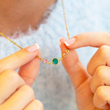 Gold plated Mother and Two Children Birthstone Link Necklace with three colourful birthstones held between the fingers, representing a mother and her two children.