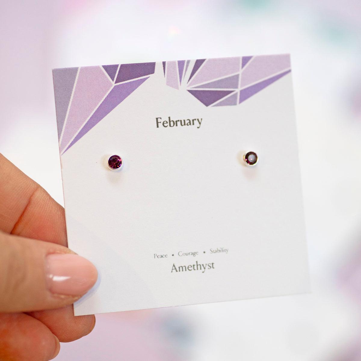 Sterling Silver Minimalist Birthstone Stud Earrings displayed shown in Amethyst on a February birthstone characteristcs card.