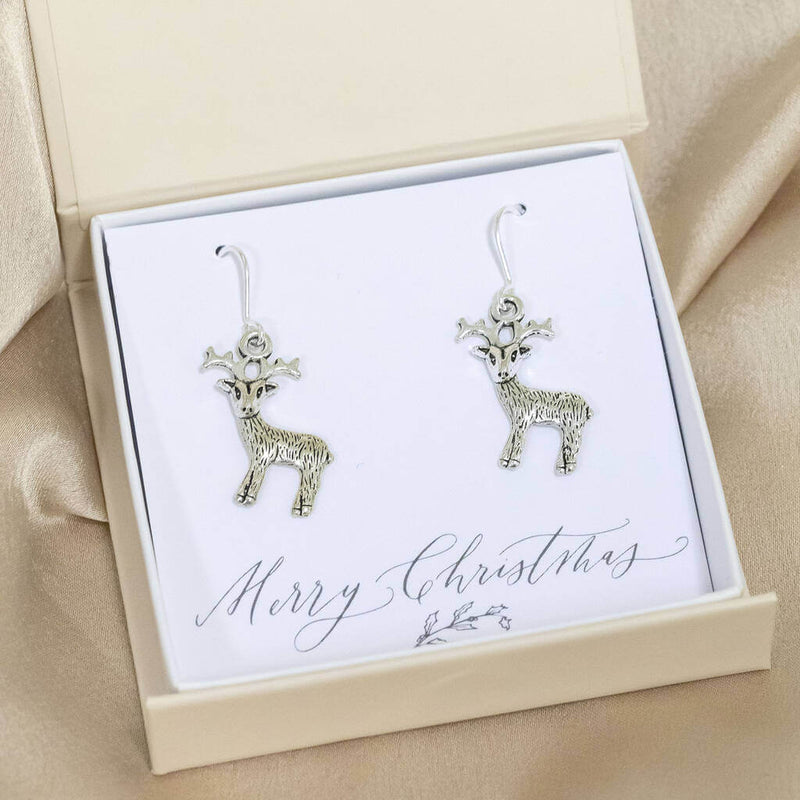 Image shows antique effect Christmas reindeer  earrings in a gift box on a Merry Christmas sentiment card