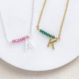  Image shows two asymmetric birthstone bar initial necklace one silver with October birthstone and A initial and the other gold with May birthstone and K initial  silver with October birthstone and A initial