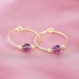 Image shows  gold beaded birthstone hoop earrings with February birthstone