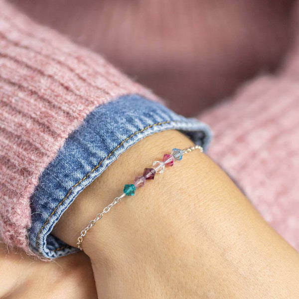 Image shows model wearing beaded family birthstone bracelet with December , June.February,April,October and March birthstones