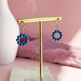 Image shows Beaded Indigo Circle Drop Earrings on a gold earring stand