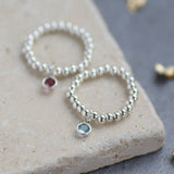 Image shows two beaded stretch birthstone charm ring with march and February birthstones