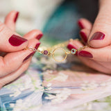 Image shows model holding Gold Friends For Eternity Birthstone Bracelet