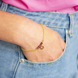 Image shows model wearing birthstone bracelet with D  initial charm  and July birthstone