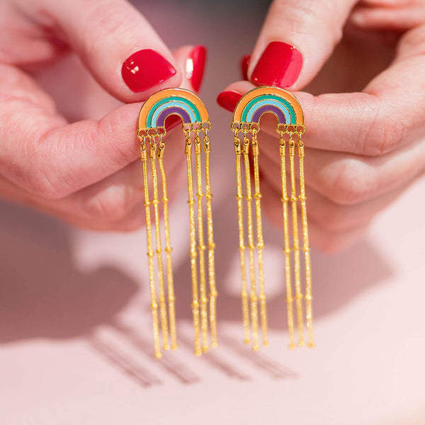 Image shows model holding boho rainbow earrings with long chain drop
